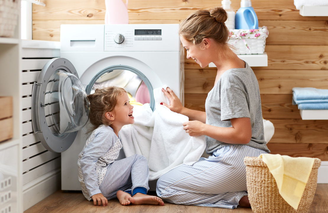 Mutter und Kind vor Waschmaschine